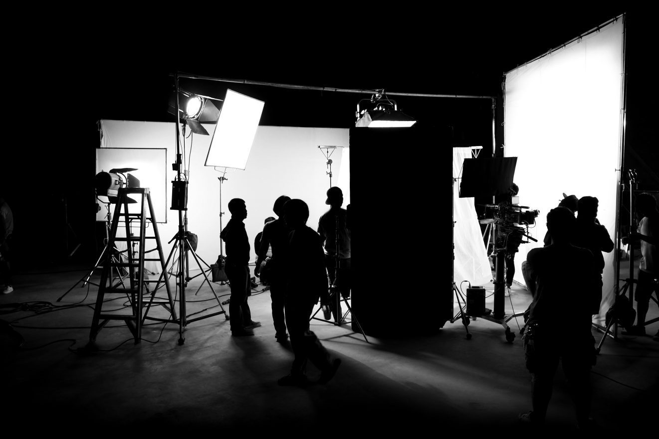 Inside of a production set with  shadows of people working around lighting and camera equipment.